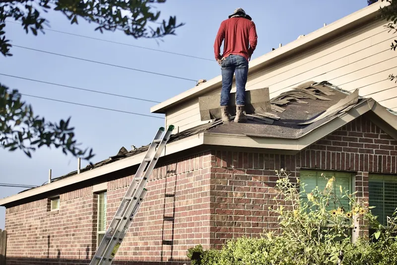 Professional roofer working on a residential roof in Rossville